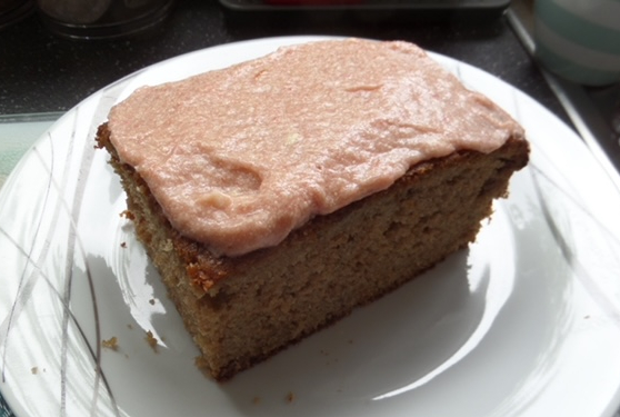 slice of cake with pink icing ona a white plate